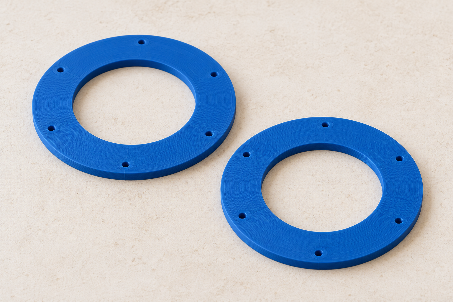 Two blue sieve clamping rings with six screw holes each — AI visualisation.
