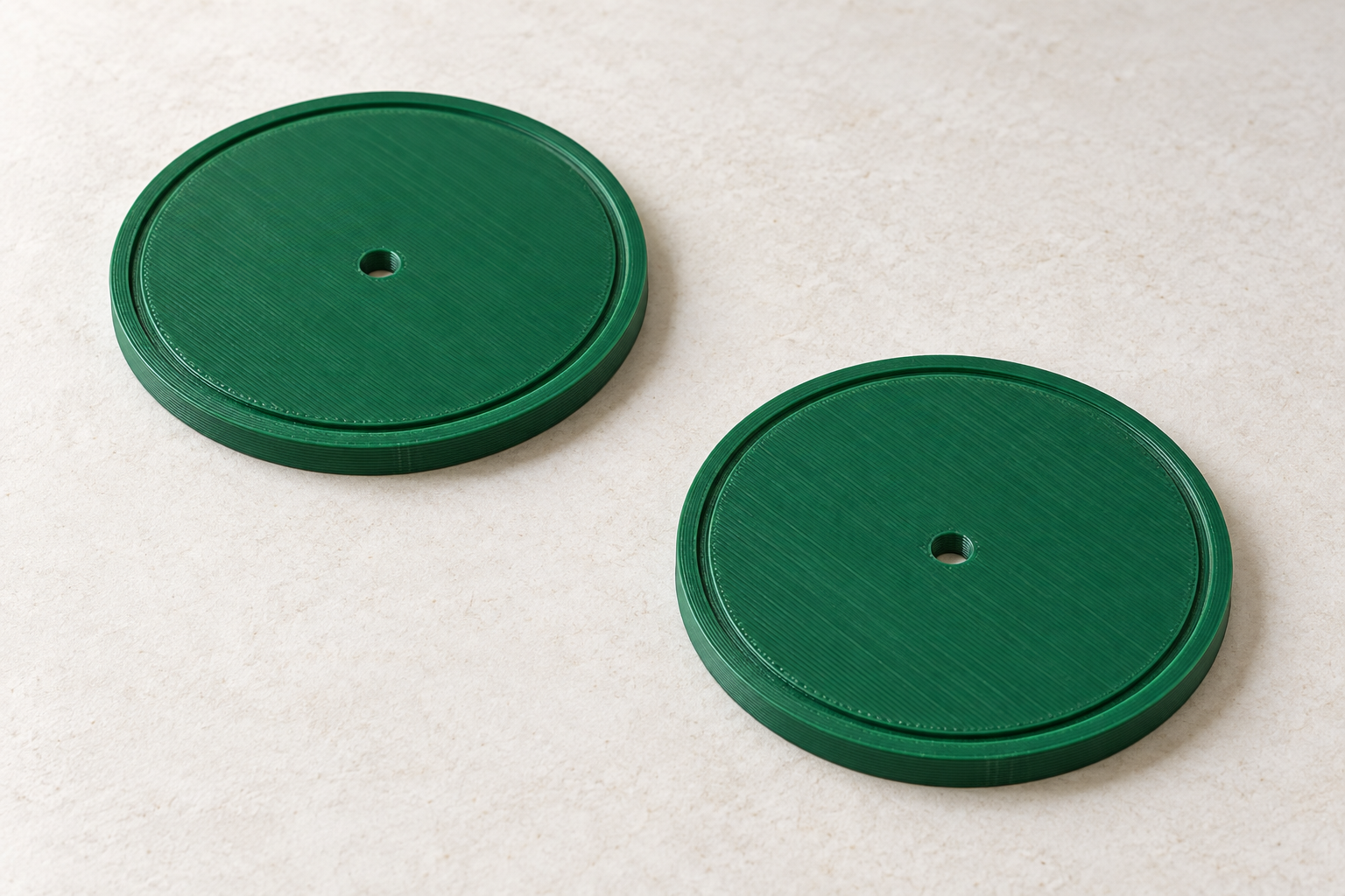 Two green label covers with gasket grooves and centre holes — AI visualisation.