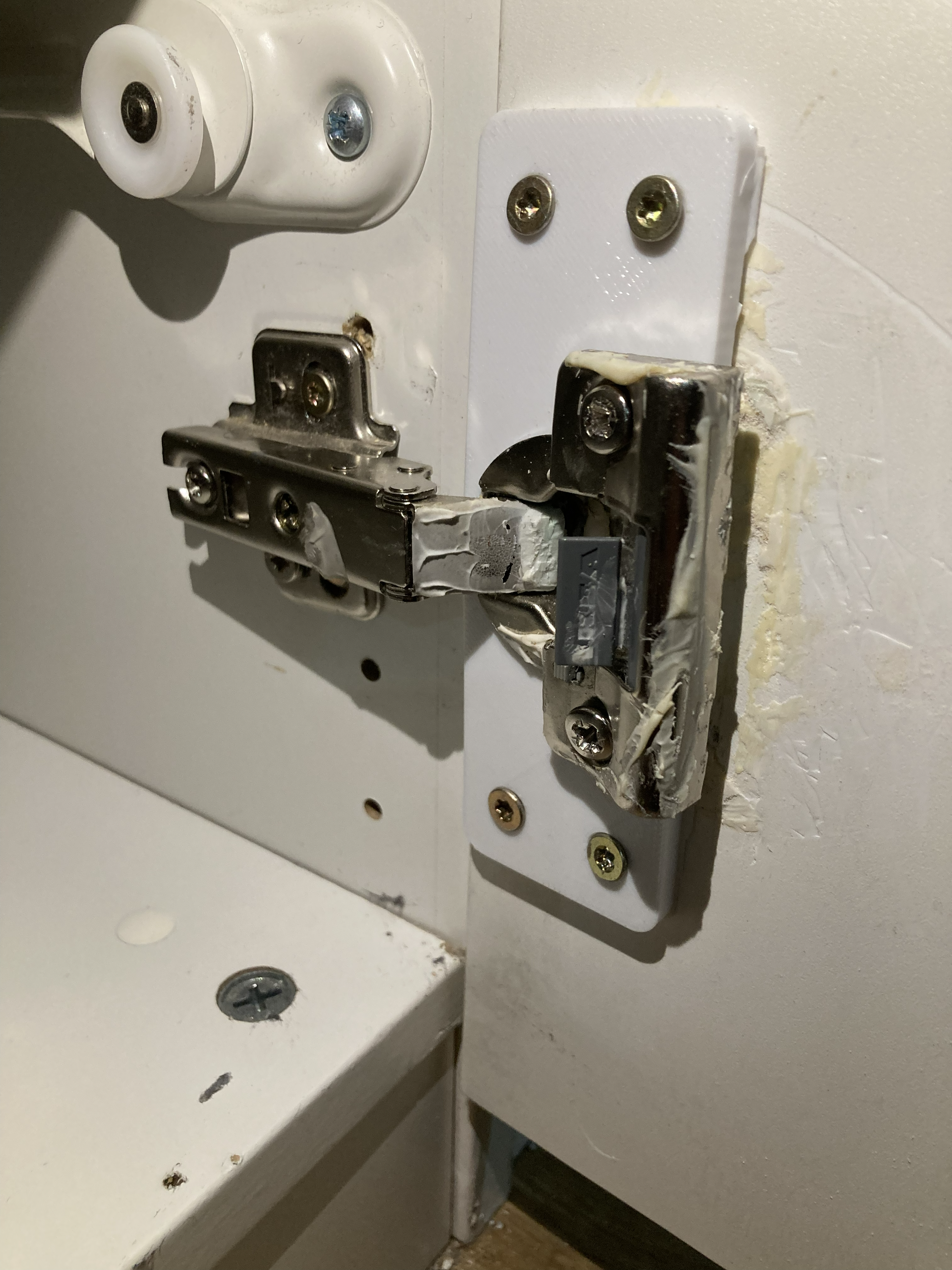 Installed repair plate for a torn-out cabinet door cup hinge